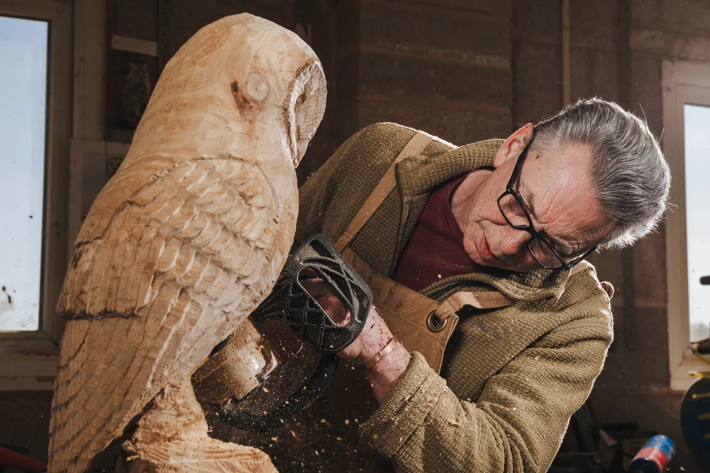 Finishing the face and eyes of a wooden barn owl carving